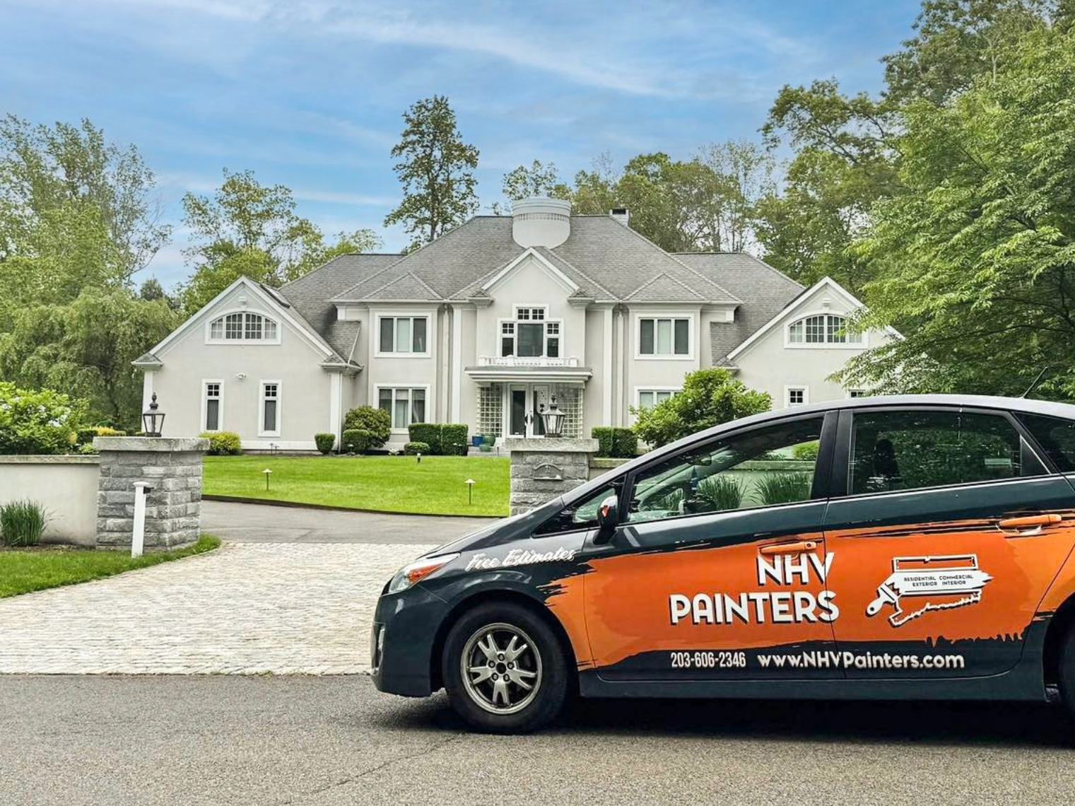 A large yellow house with a lush green lawn in front of it