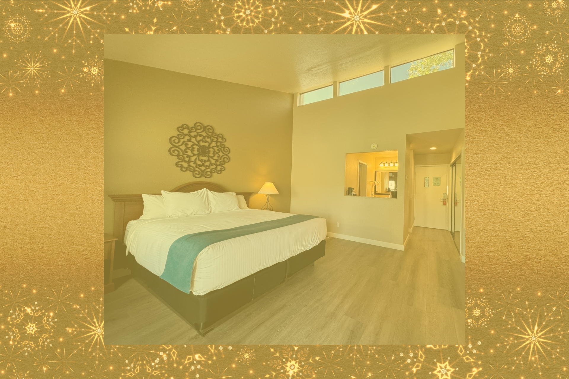 photo of guest room featuring large bed with white bedding and blue blanket 