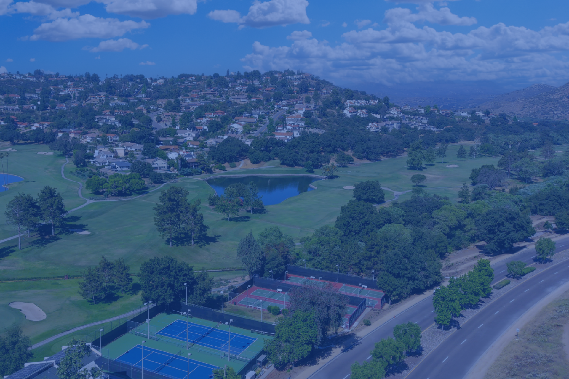 aerial view of golf course, tennis courts, and pickleball courts