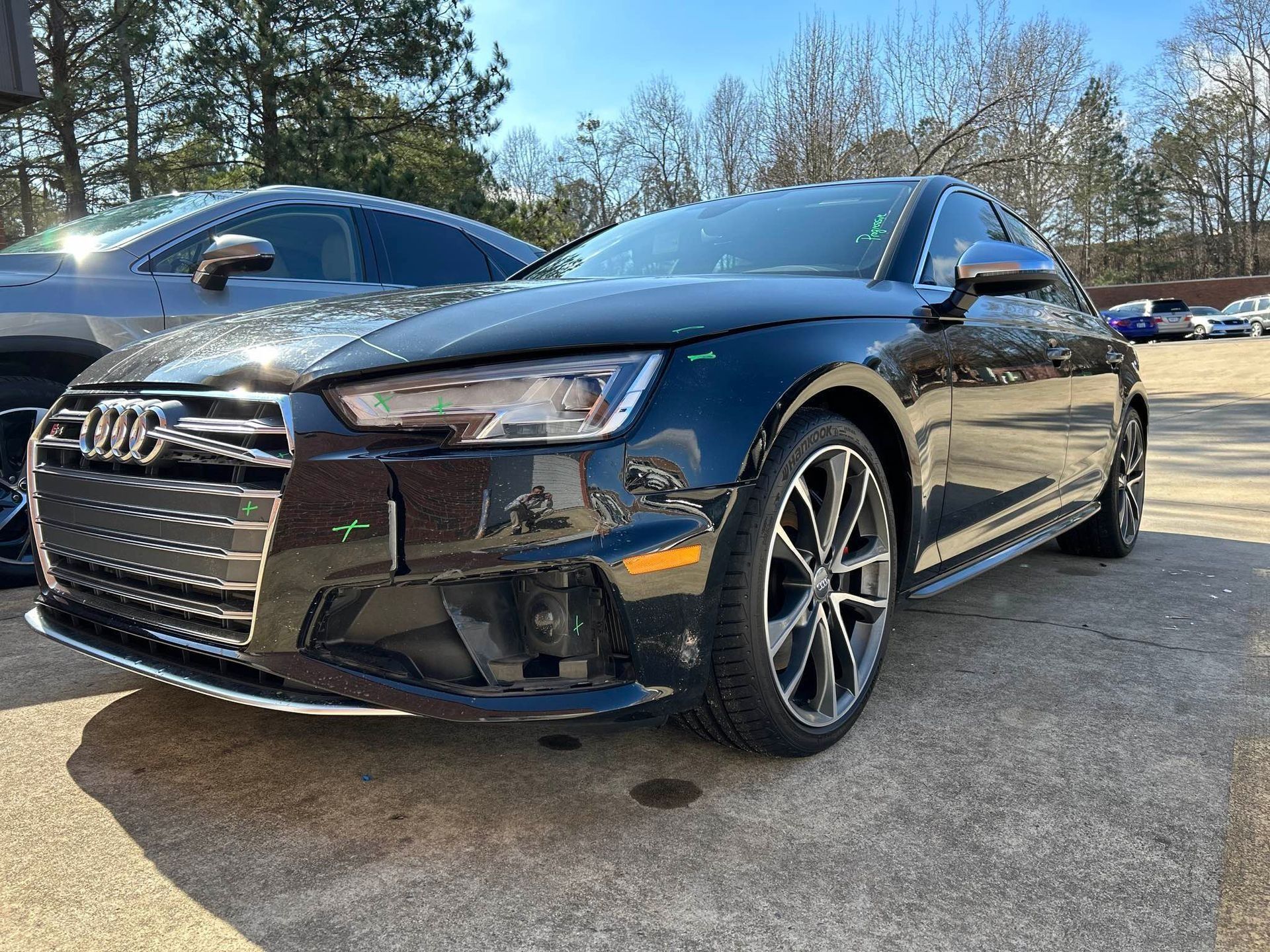 Black Audi sedan parked outdoors on a sunny day, front three-quarter view