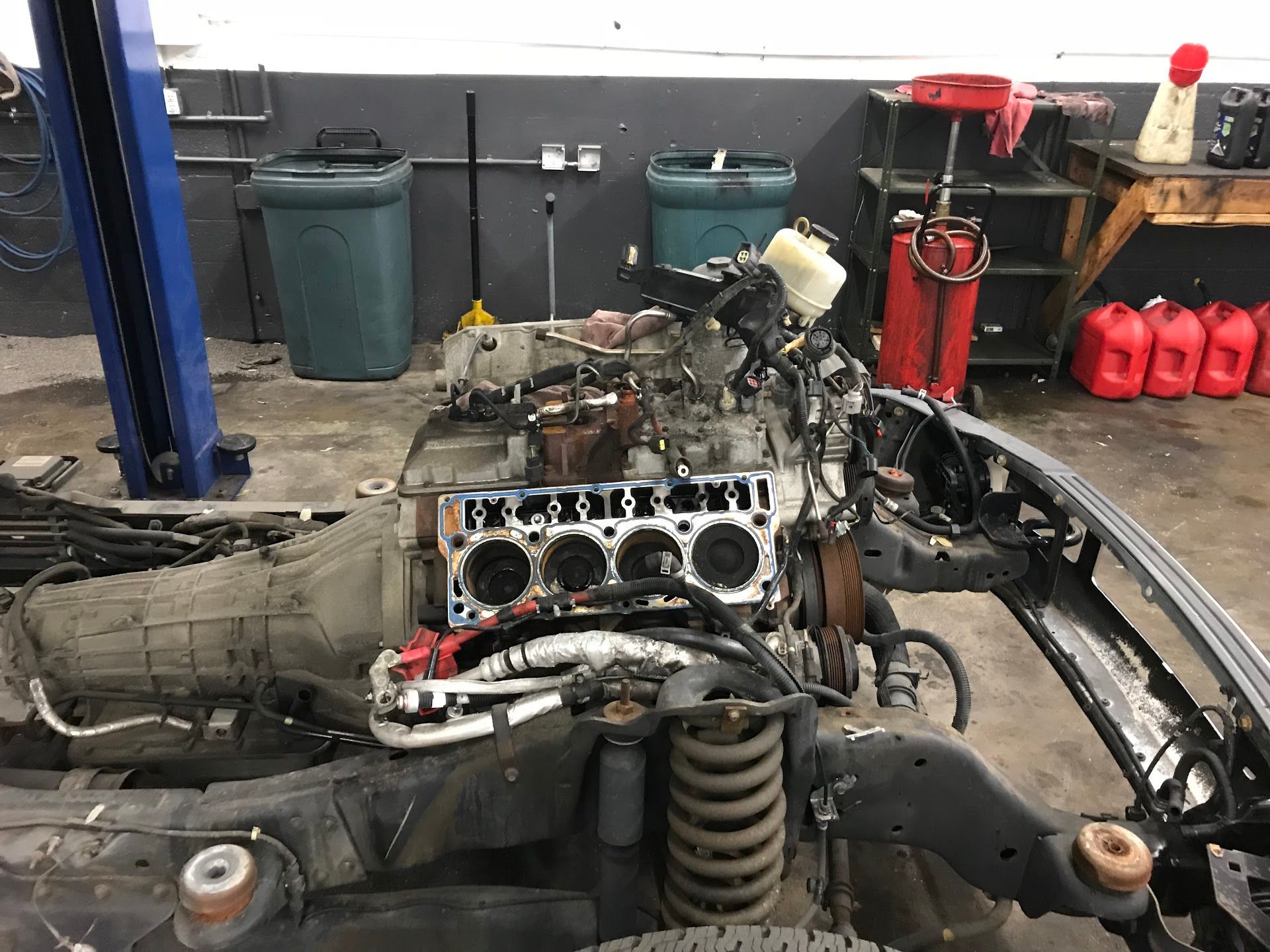 An automotive repair shop showing a vehicle engine block exposed on a chassis with surrounding tools and equipment. | A-Affordable Auto Repair