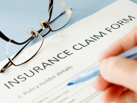 A person is filling out an insurance claim form.