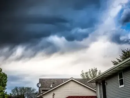 A house with a stormy sky in the background.