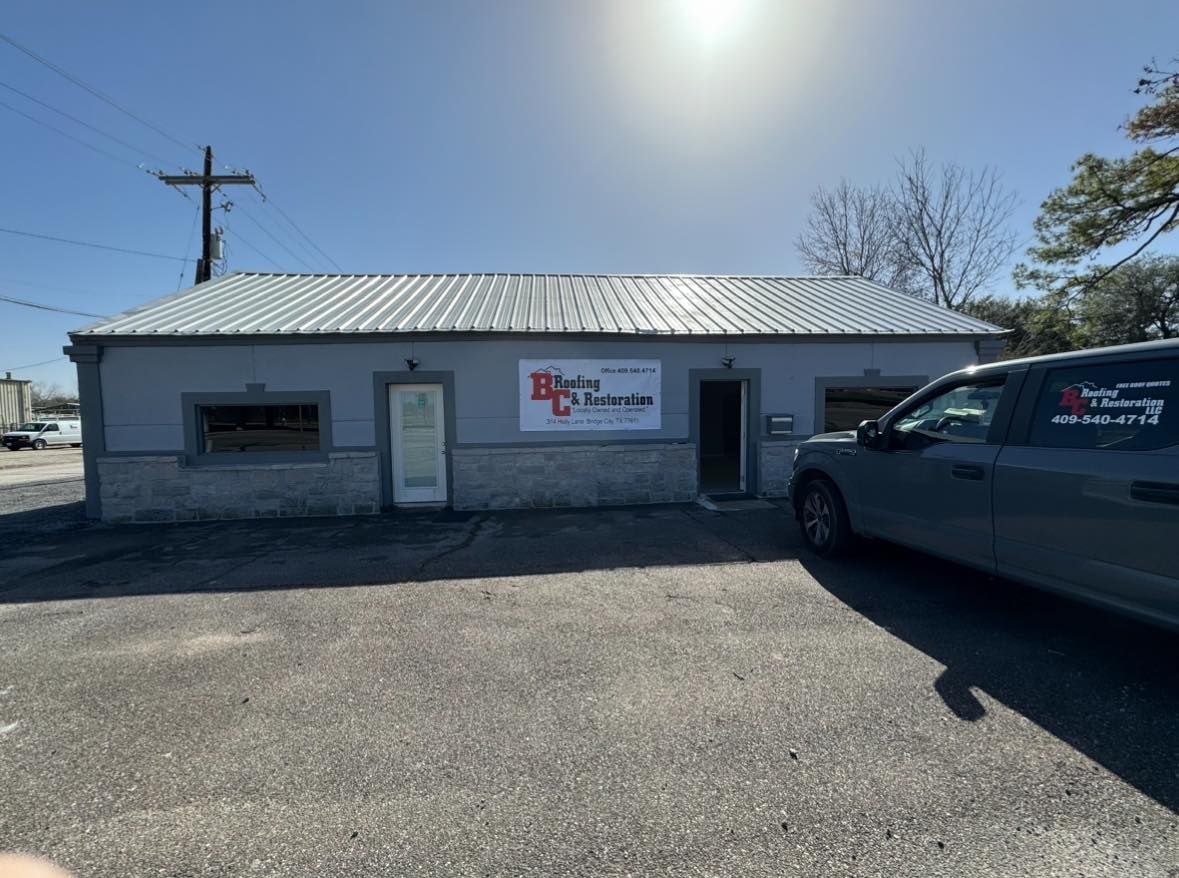A gray van is parked in front of a building.
