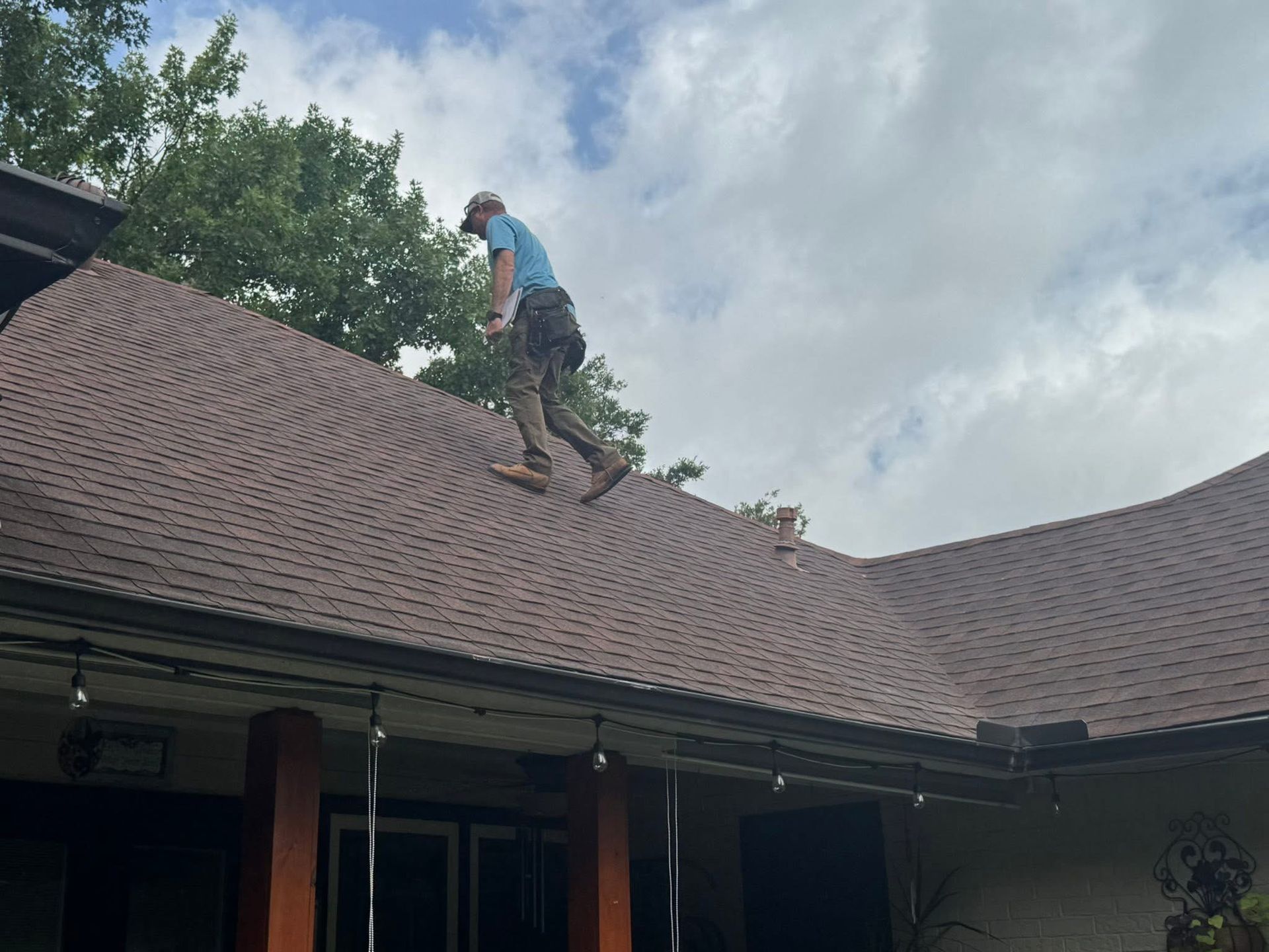 A man is standing on top of a roof.