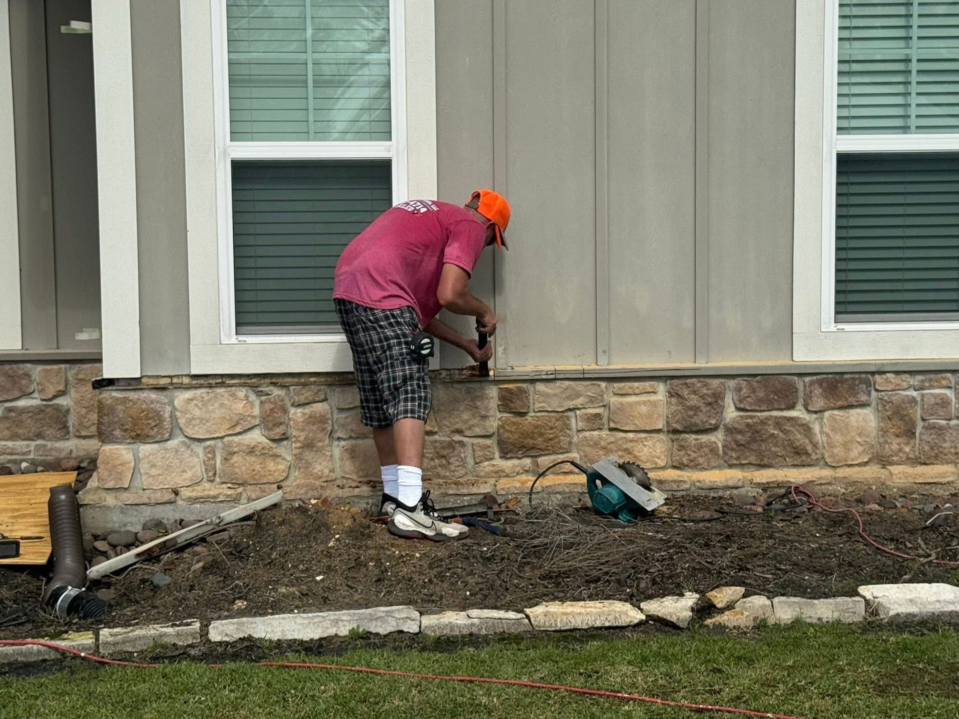 A man is working on the side of a house.