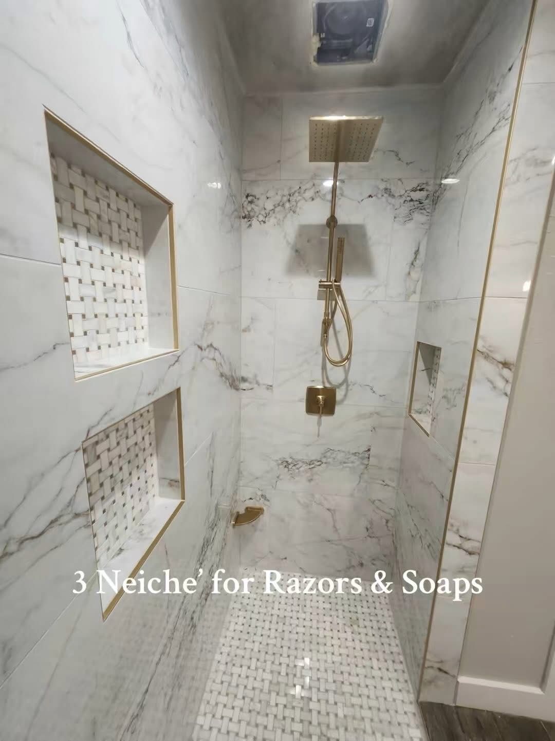 A bathroom with marble walls and a walk in shower.