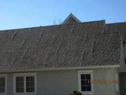 A white house with a gray roof and a blue sky in the background.
