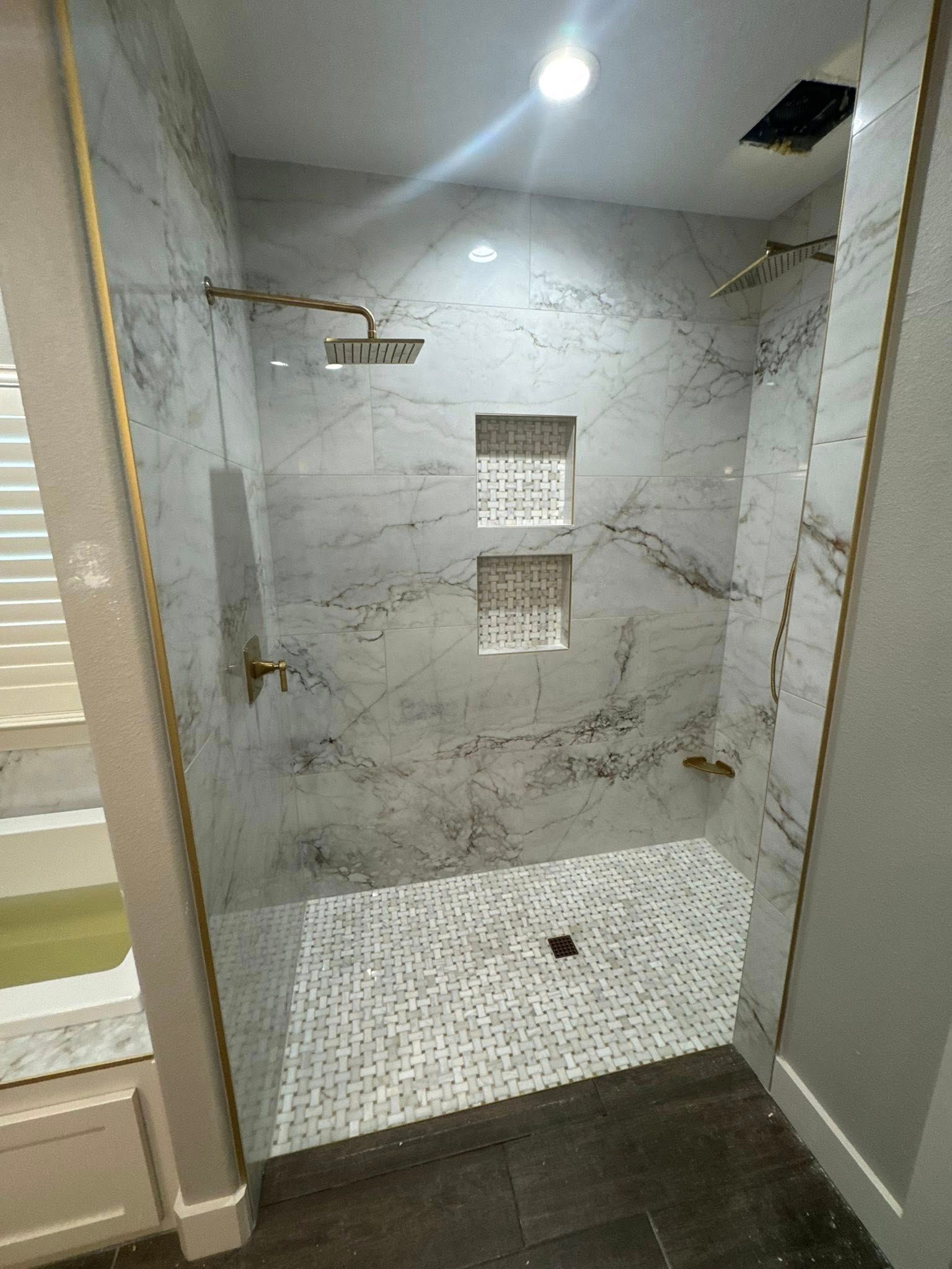 A bathroom with a walk in shower and a bathtub.
