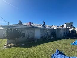 A group of people are working on the roof of a house.