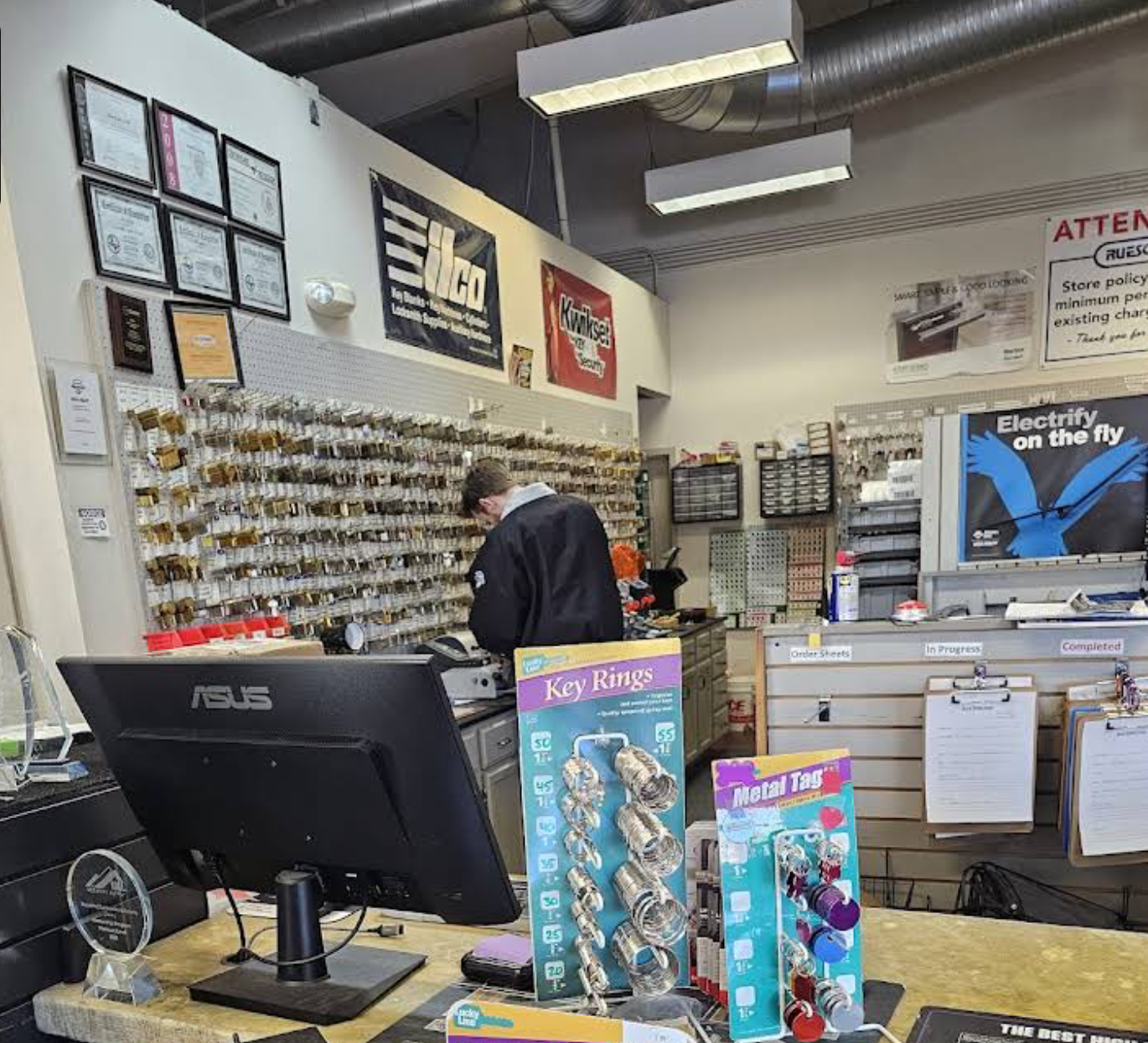 Interior of Rueschhoff Locksmiths showing the locksmiths making a copy of a key.