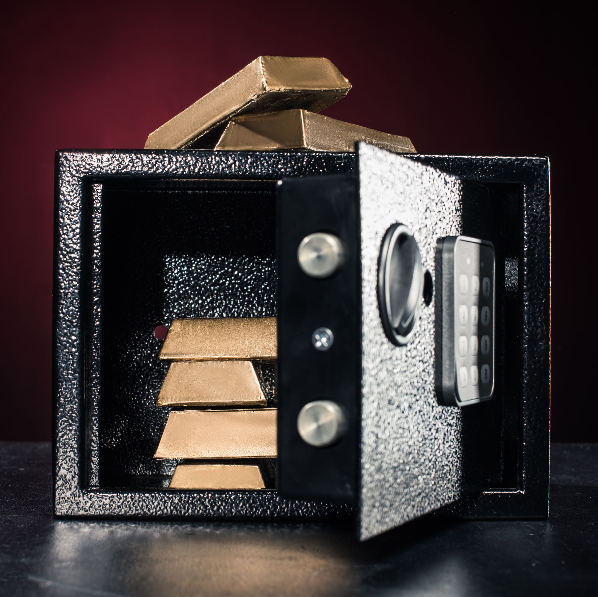 Image of a safe with gold bars in it and on it.