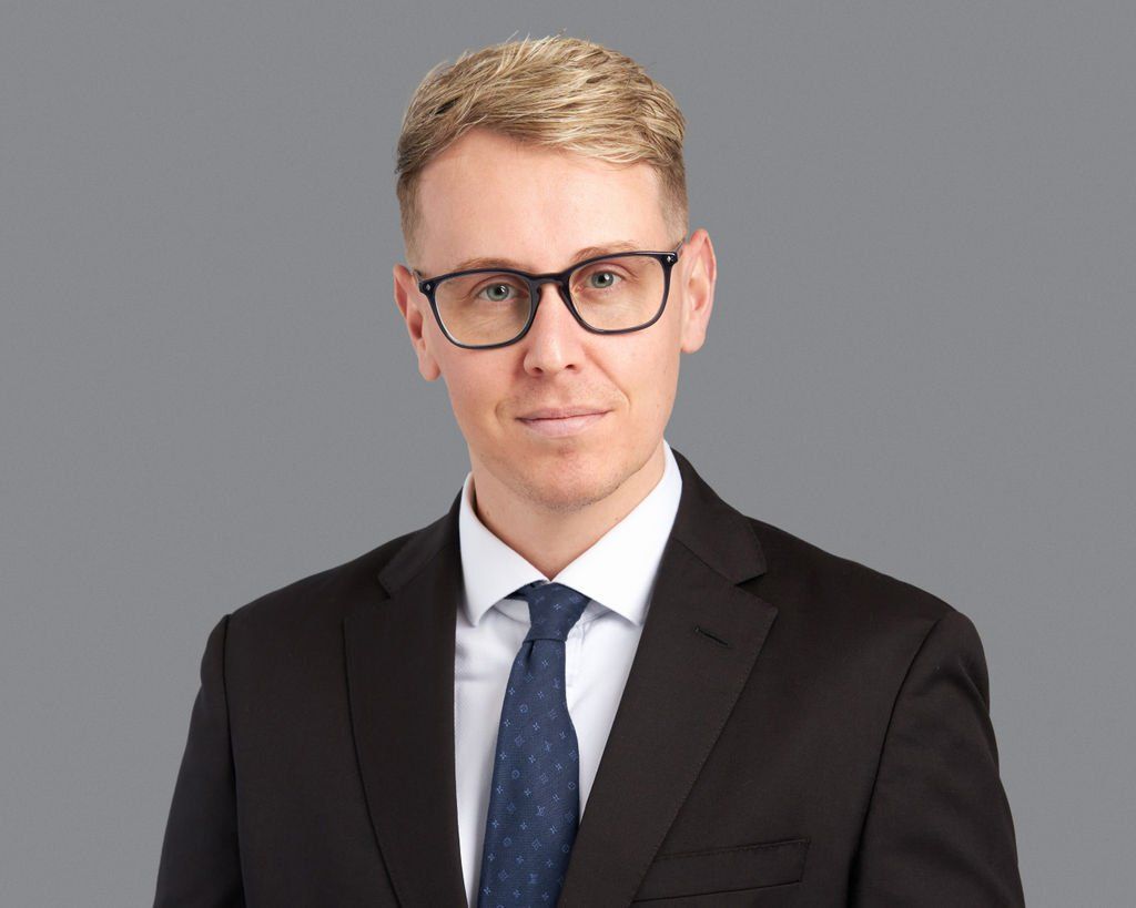 A man in a suit and tie is wearing glasses.