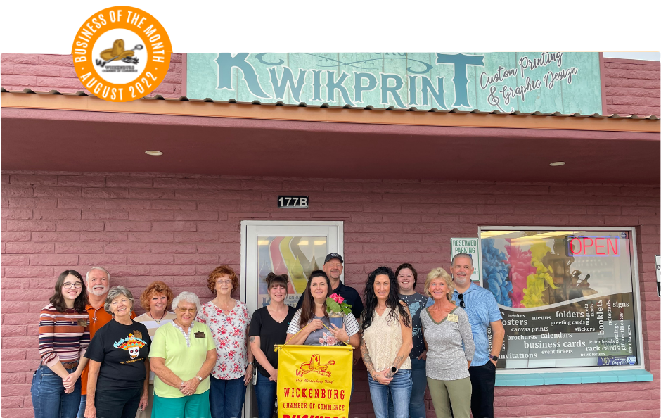 Group of people standing outside Kwikprint, a print shop. 