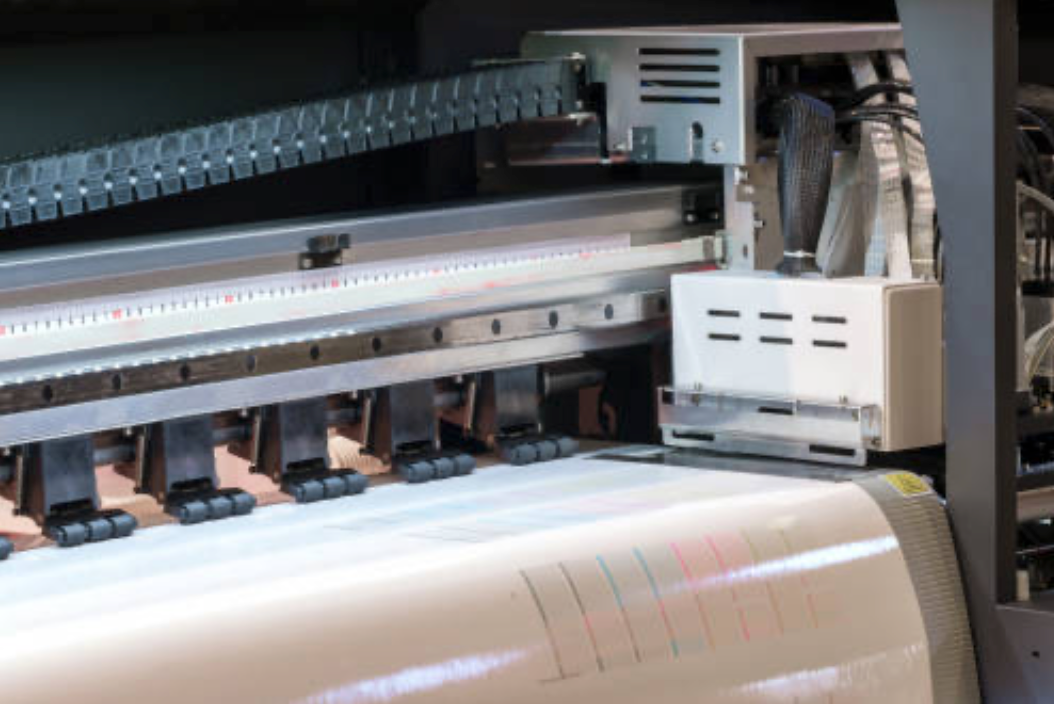 Large format printer printing on white paper.