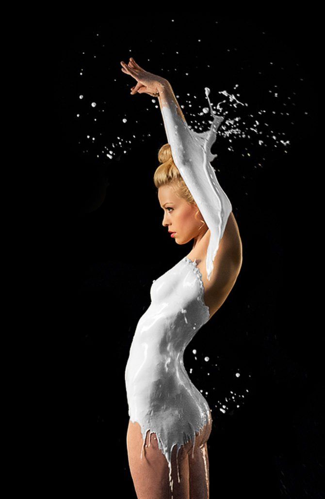 Eine Frau in einem weißen Kleid ist mit Milch bedeckt.