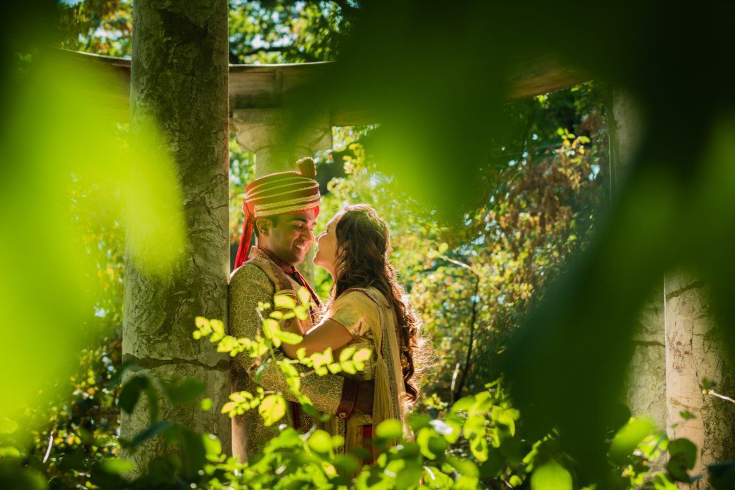 Eine Braut und ein Bräutigam küssen sich im Wald.