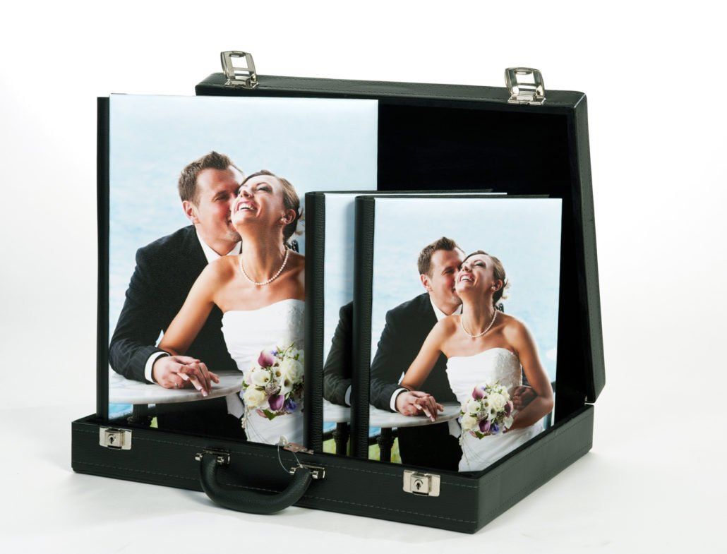 Eine Braut und ein Bräutigam küssen sich in einem schwarzen Koffer