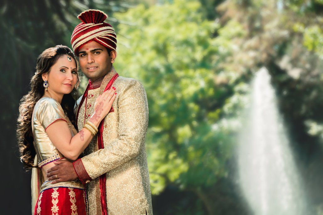 Eine Braut und ein Bräutigam posieren für ein Foto vor einem Wasserfall.