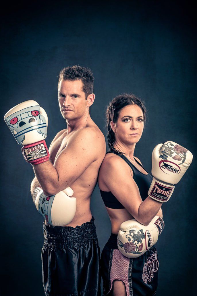 Ein Mann und eine Frau stehen Rücken an Rücken und tragen Boxhandschuhe.