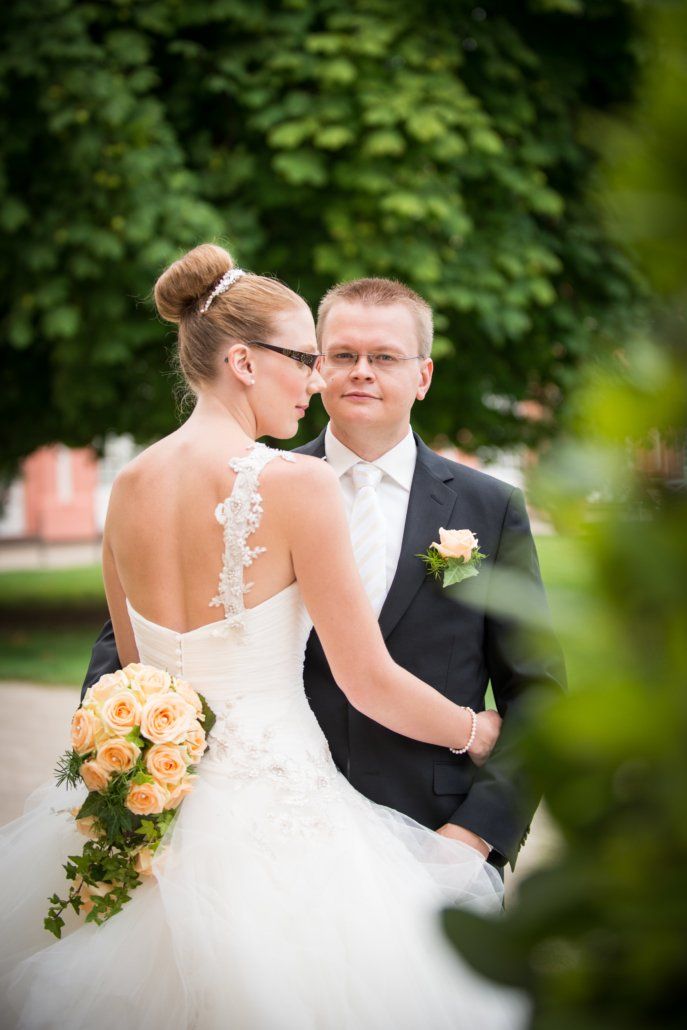 Eine Braut und ein Bräutigam stehen nebeneinander in einem Park.