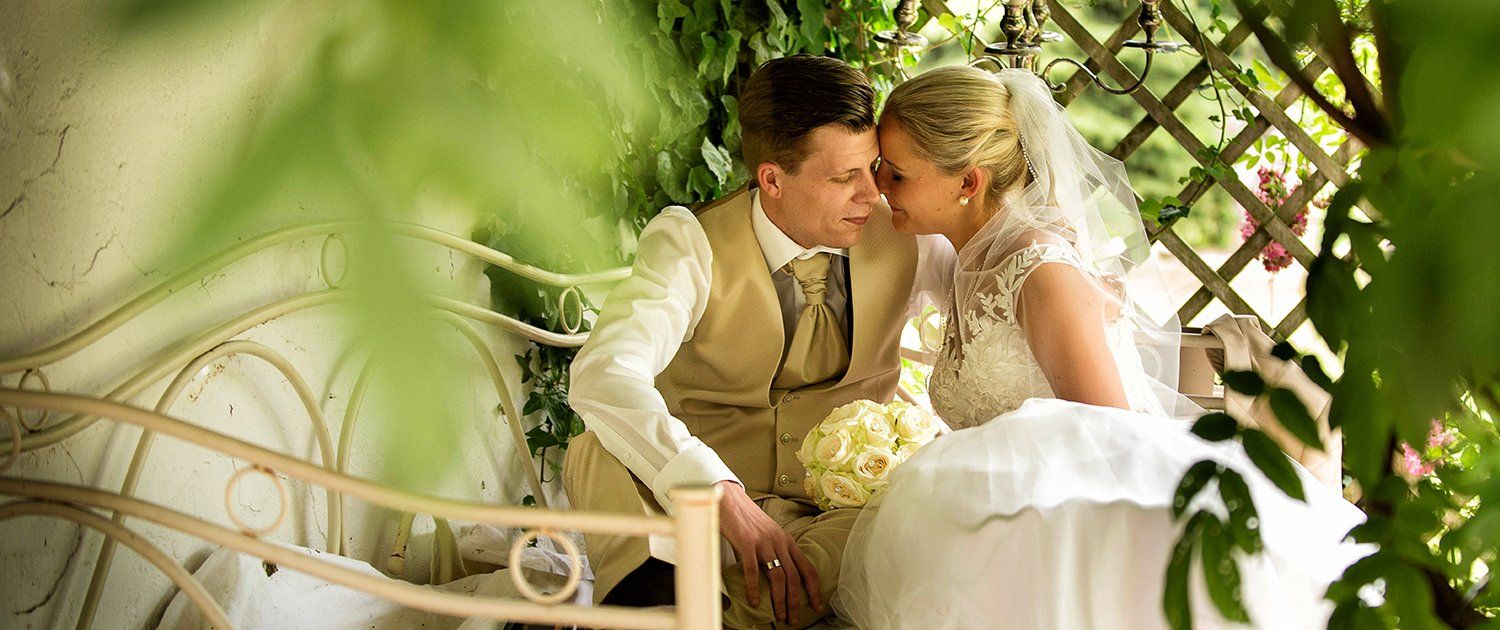 Eine Braut und ein Bräutigam küssen sich in einem Pavillon.
