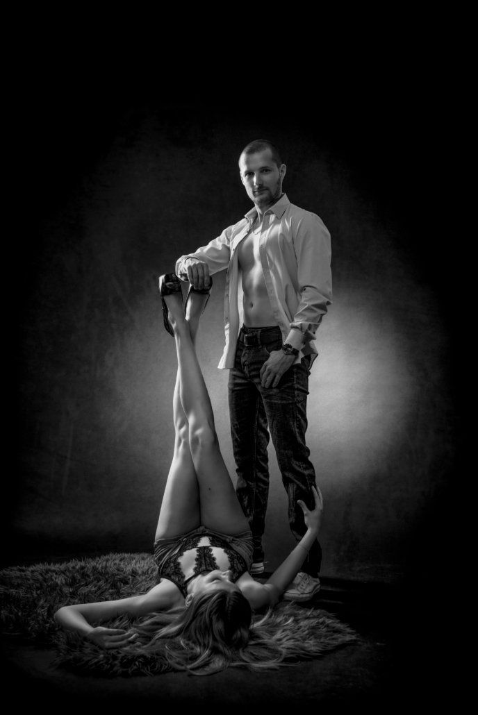 Ein Mann steht neben einer Frau, die auf dem Boden liegt.