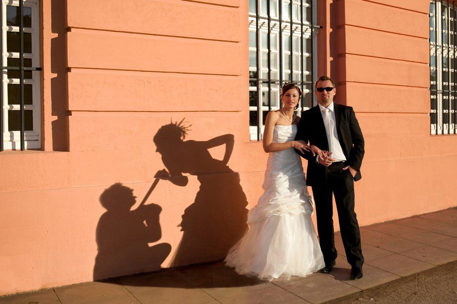 Eine Braut und ein Bräutigam posieren für ein Foto mit ihren Schatten an der Wand