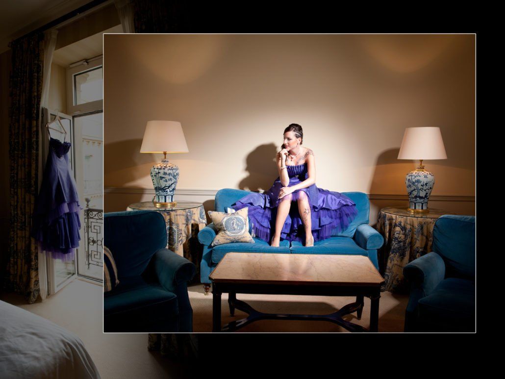 Eine Frau in einem blauen Kleid sitzt auf einer blauen Couch