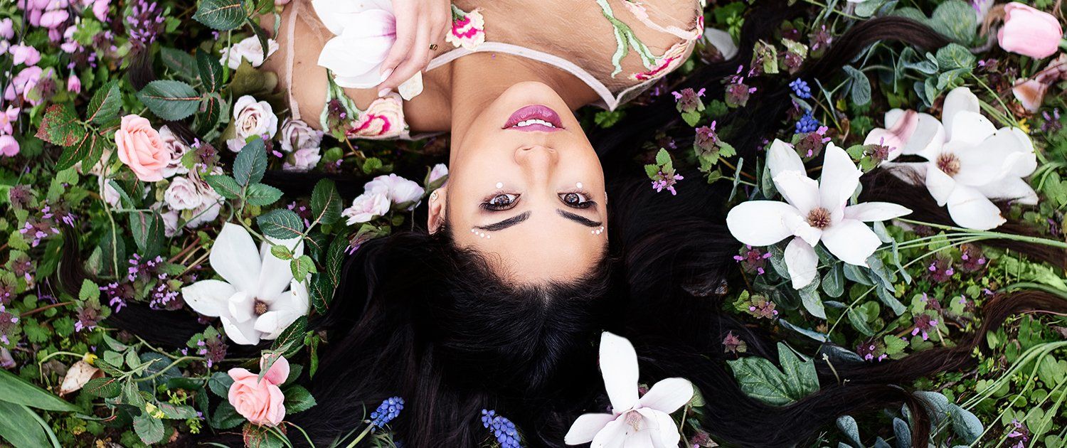 Eine Frau liegt auf dem Rücken in einem Blumenfeld.