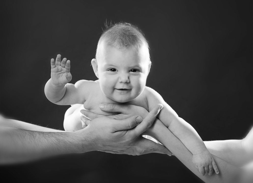 Ein Schwarzweißfoto eines Babys, das von einer Person gehalten wird