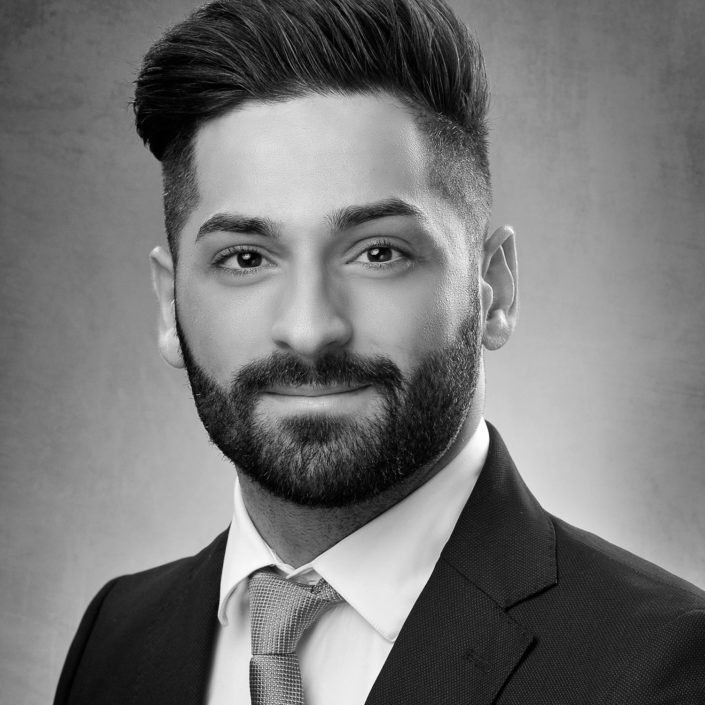 Ein Mann mit Bart trägt Anzug und Krawatte.