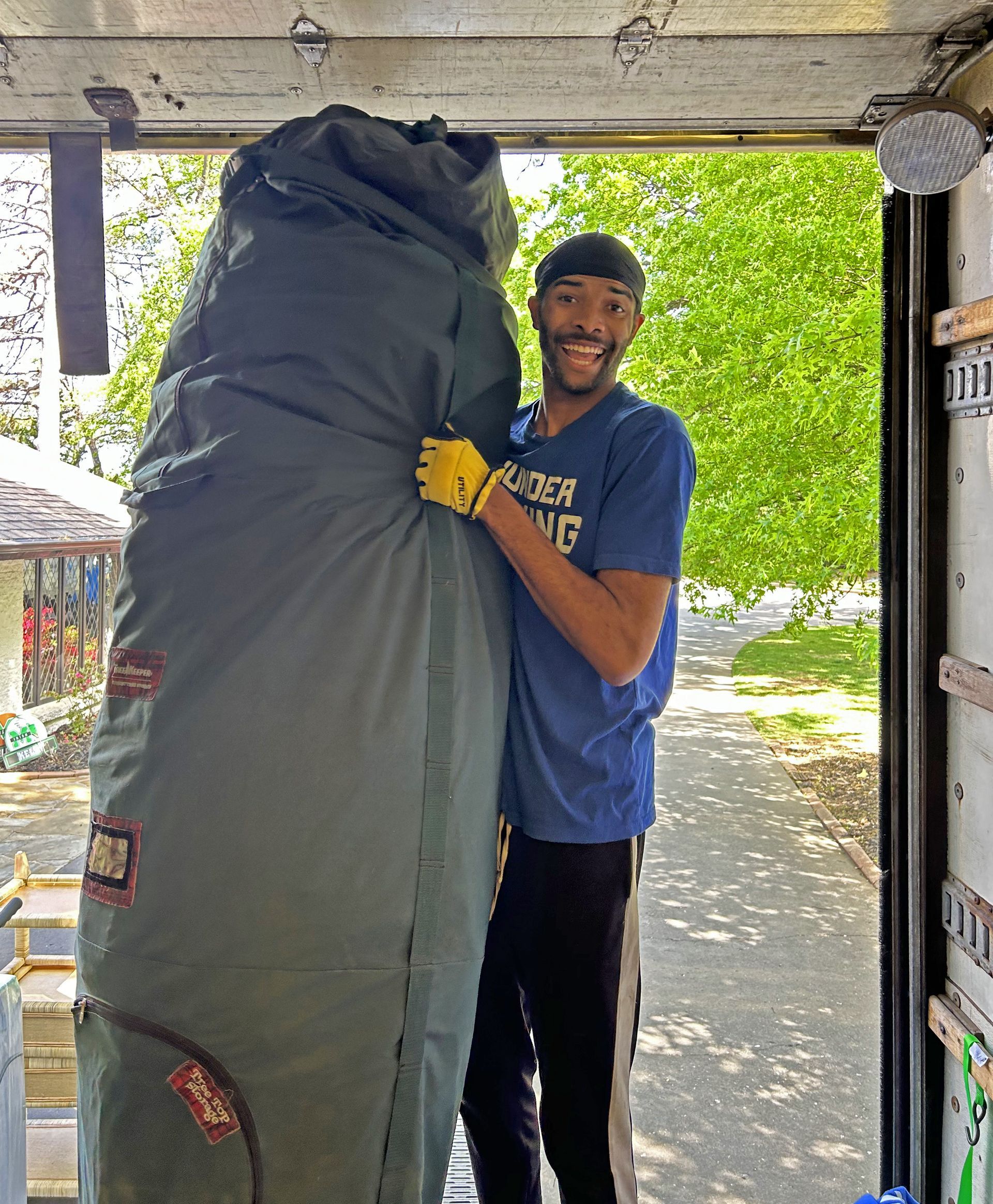 A Thunder Moving employee smiling for the camera while loading a moving truck in OKC.