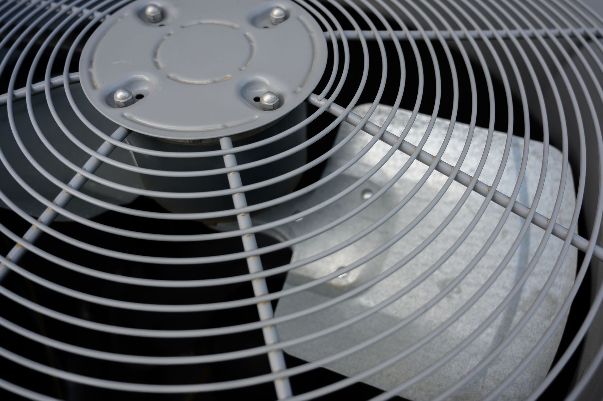 Close-up of a gray air conditioning unit fan grill with visible blades.