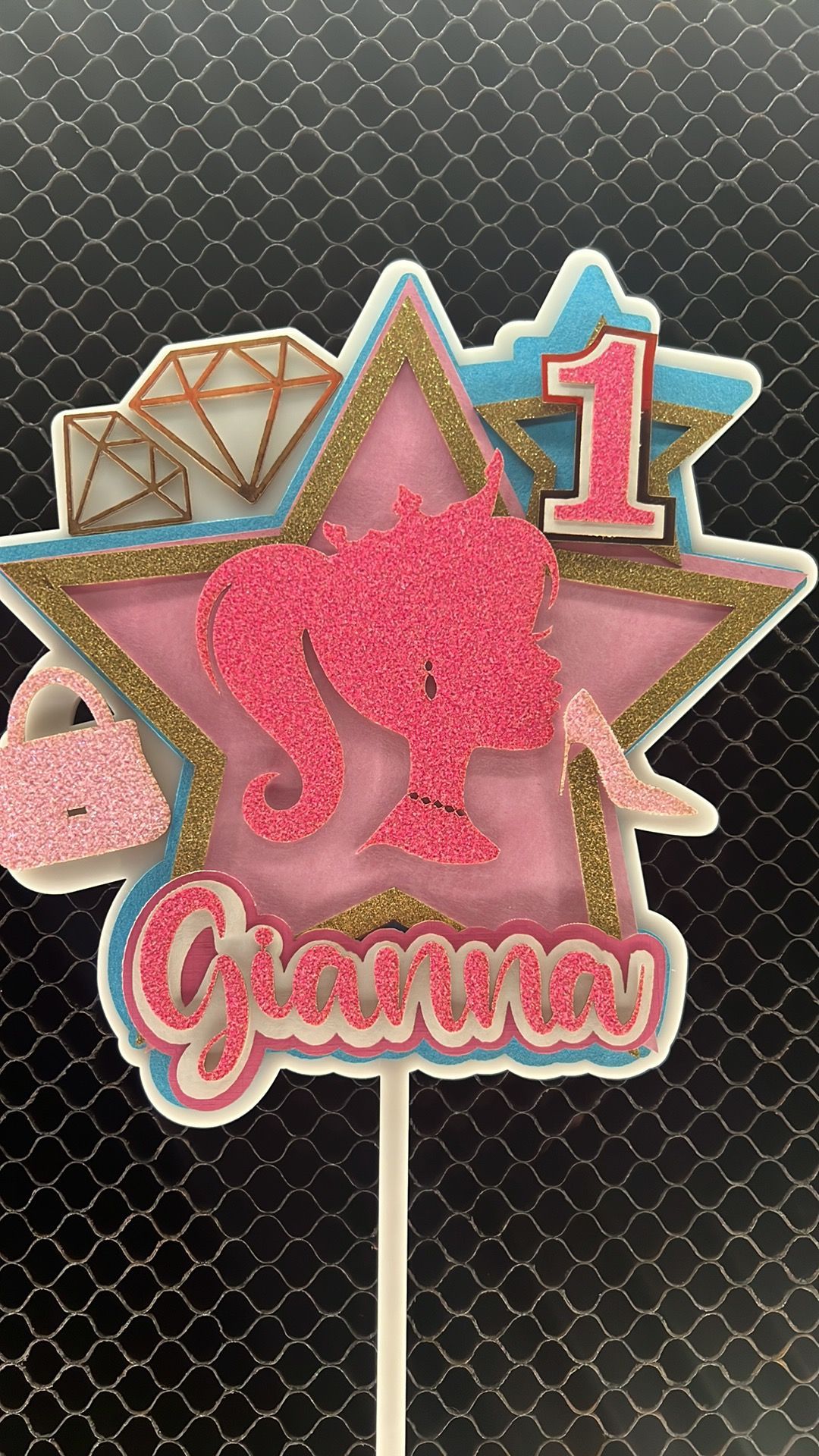 A barbie cake topper for a girl 's first birthday.