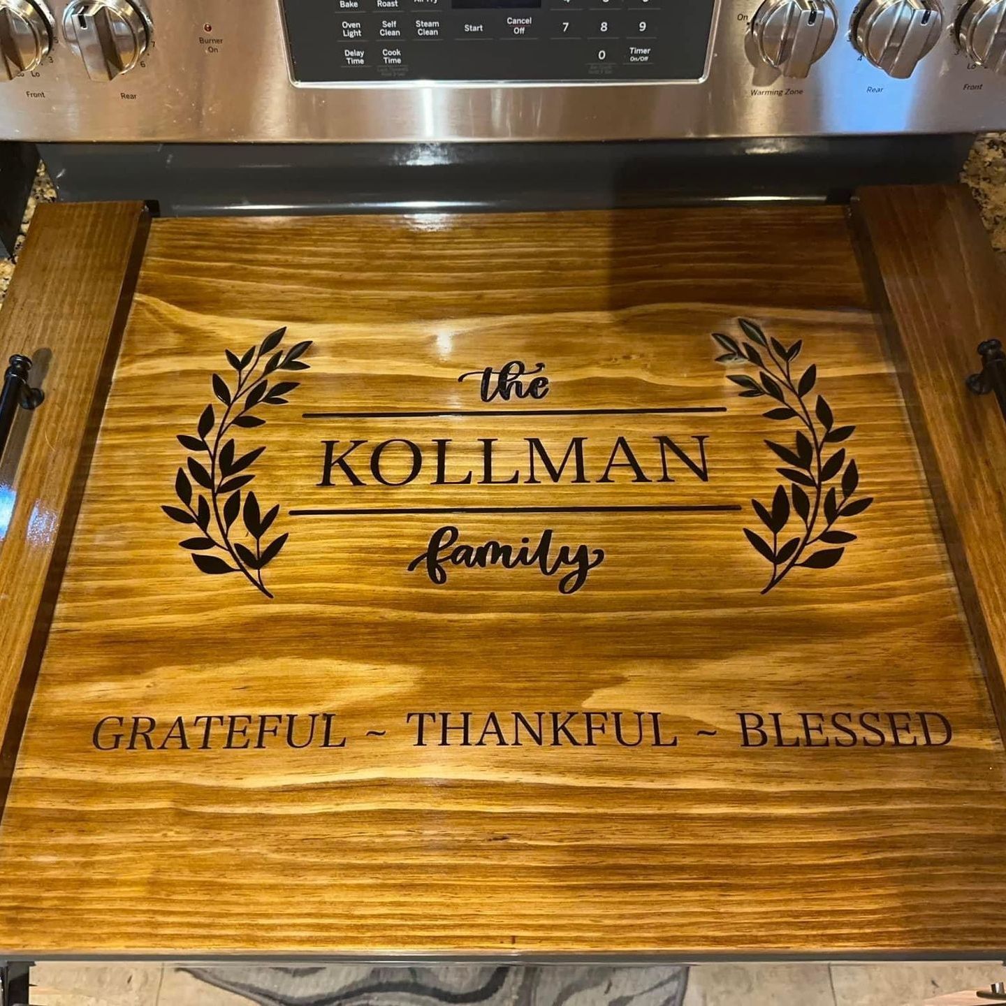 A wooden stove top cover with the words `` grateful thankful blessed '' written on it.