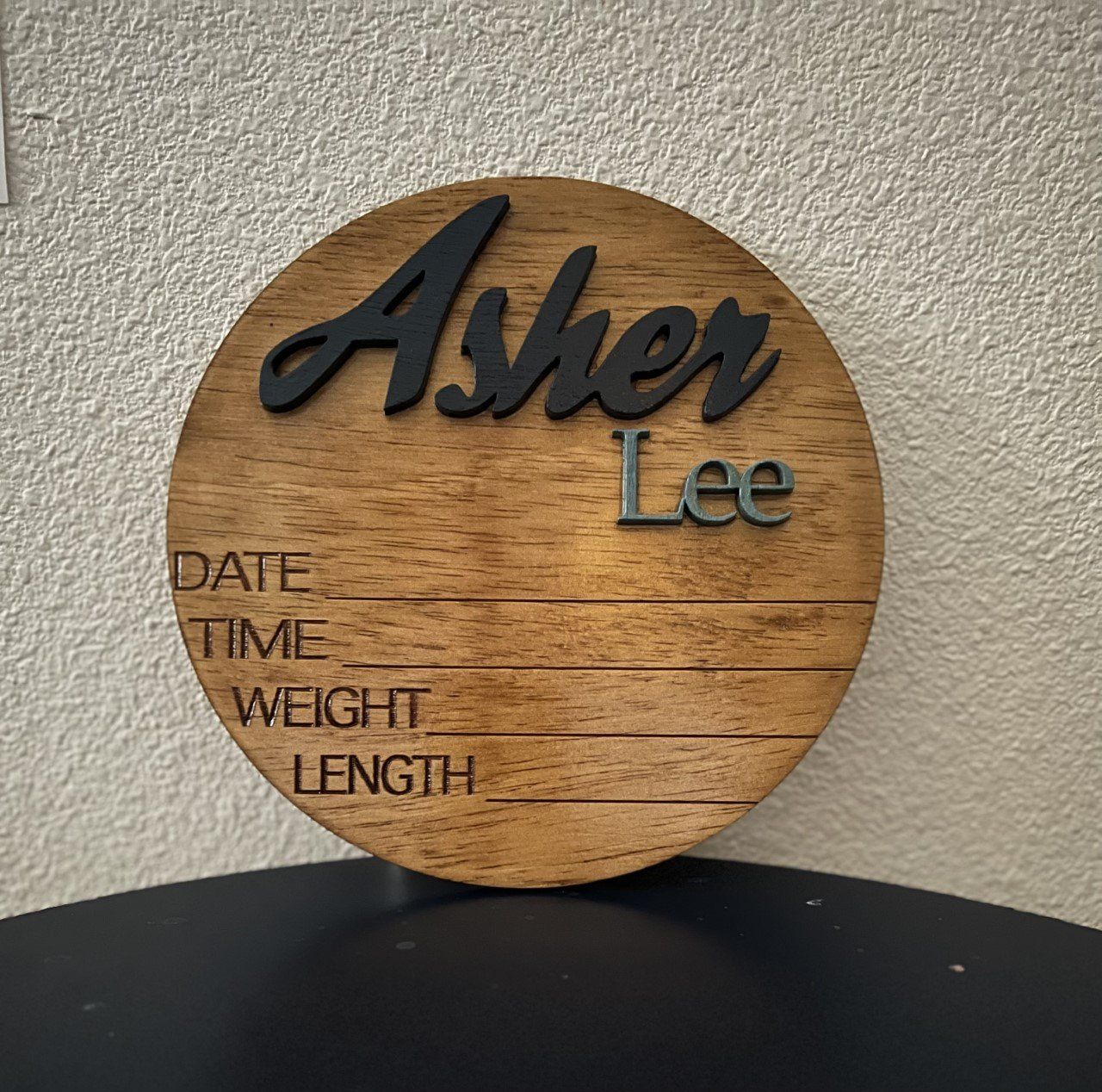 A wooden sign with the name asher lee on it