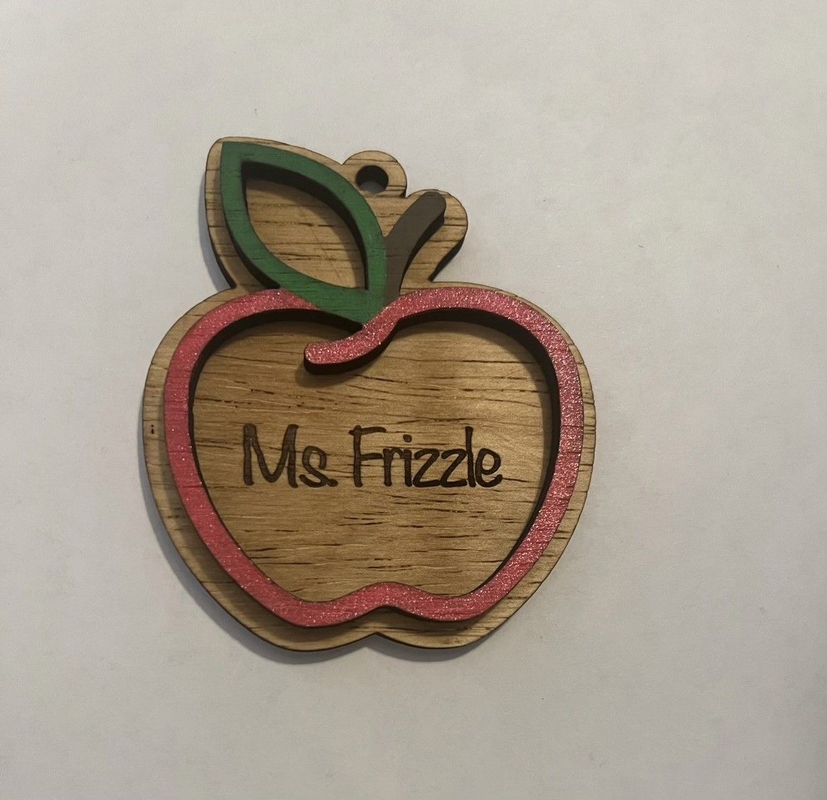 A wooden apple with the name ms frizzle on it