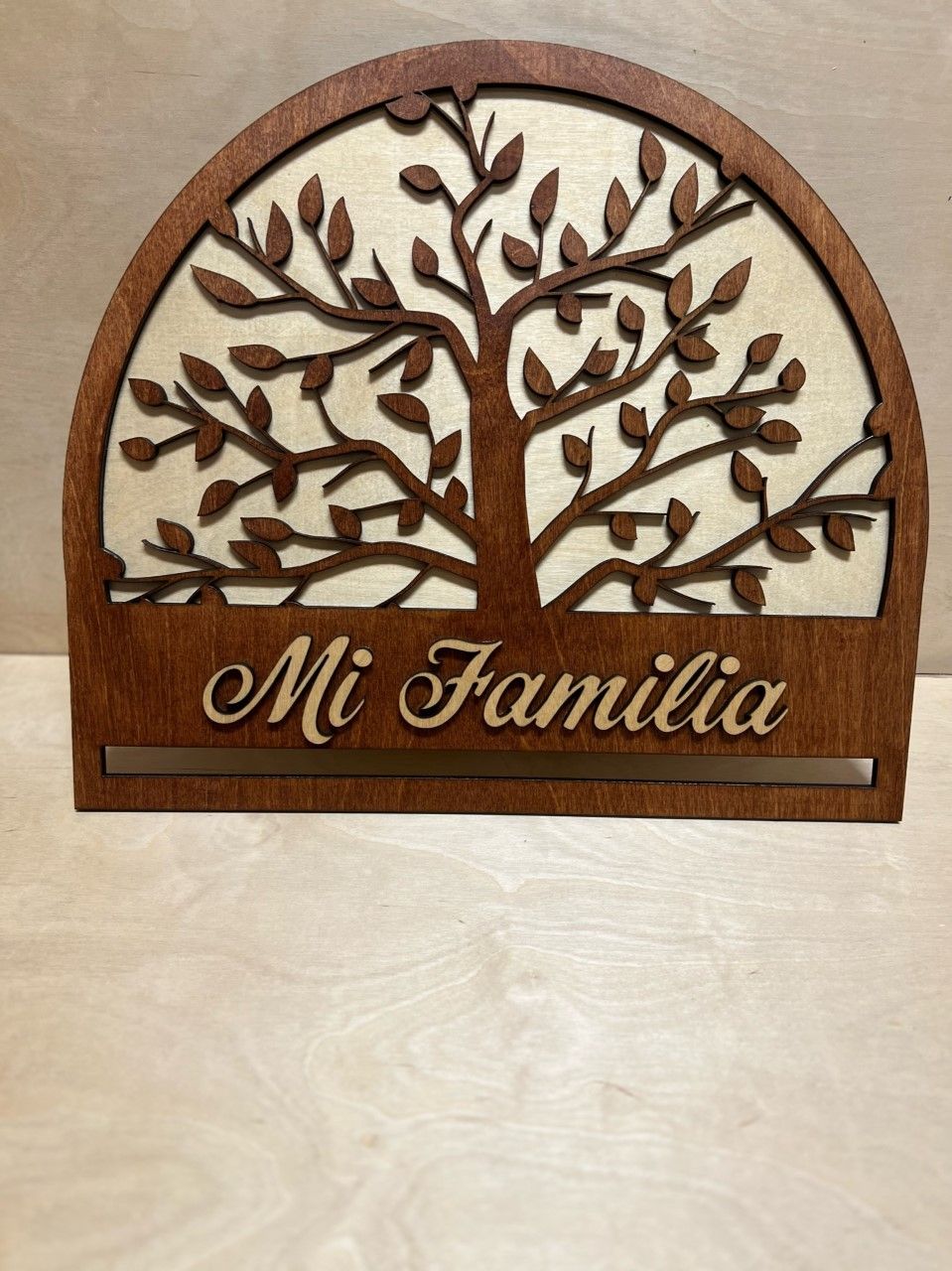 A wooden sign with a tree and the name mi familia on it.