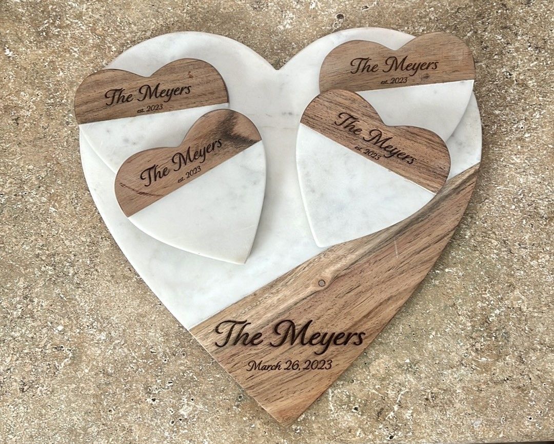 A heart shaped cutting board with wooden hearts and the name the meyers on it.