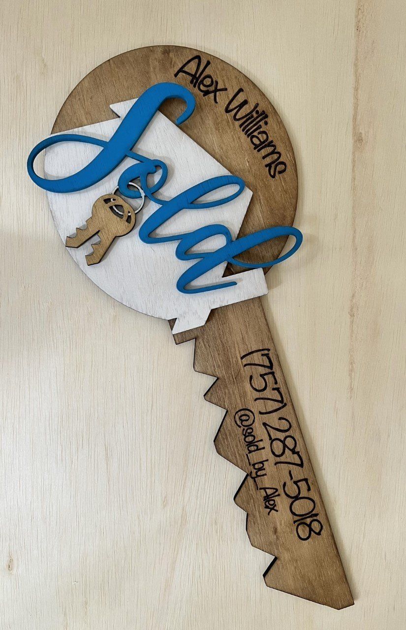 A wooden key with the word sale on it