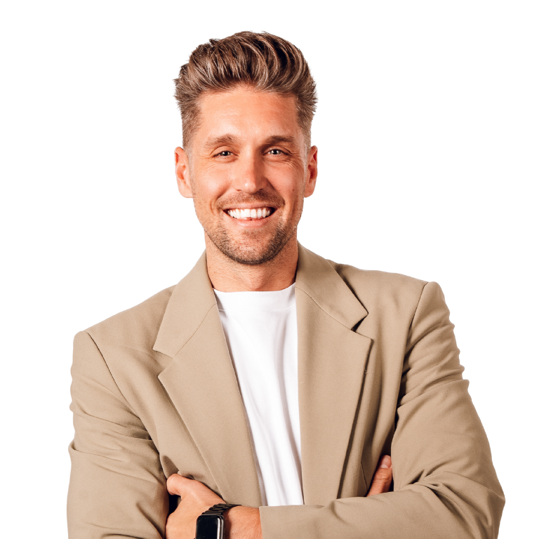 Man in tan blazer smiles, arms crossed, on blue gradient background.