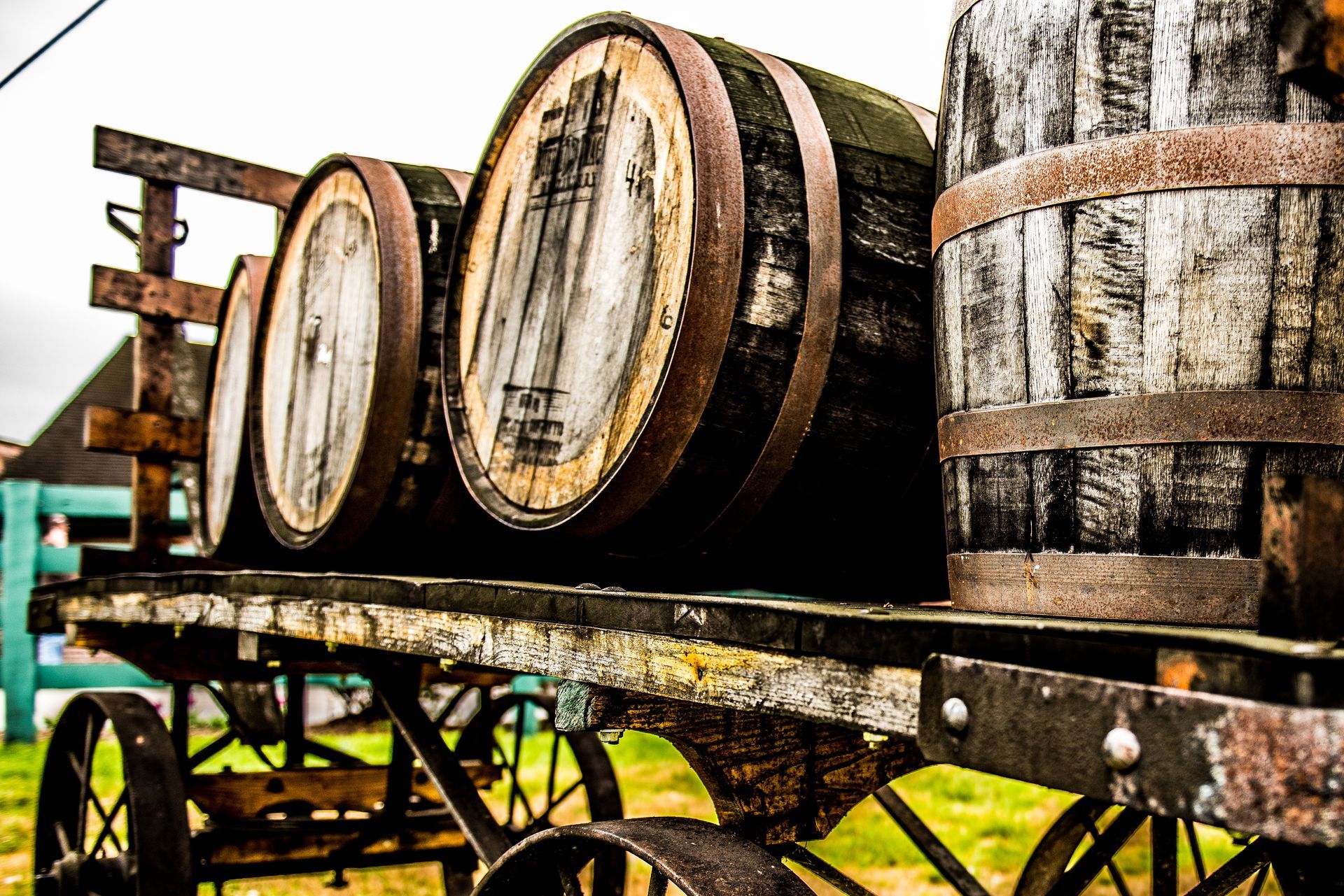 A bunch of wooden barrels are sitting on top of a wooden cart.