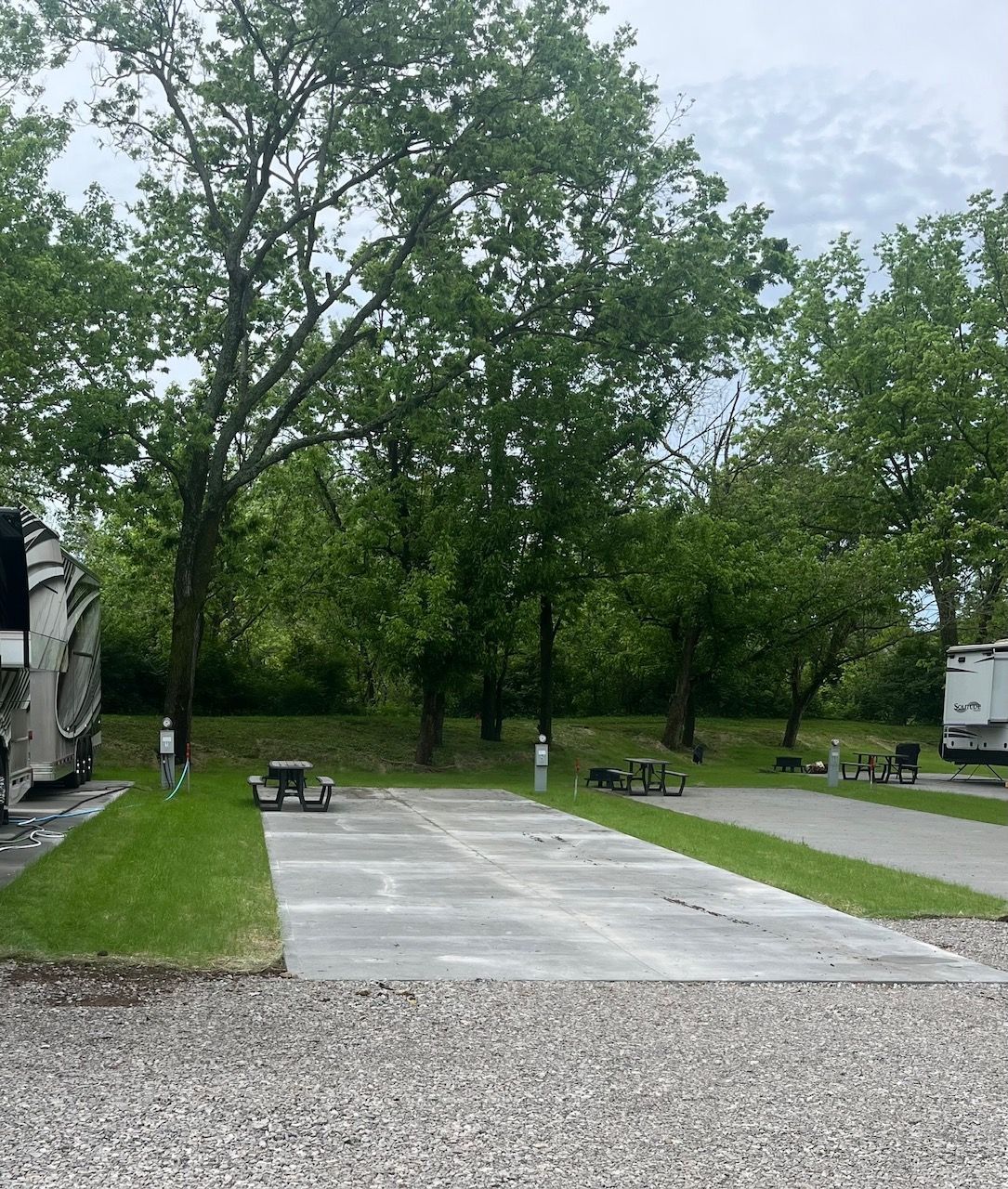 A rv parked in a grassy area with trees in the background.