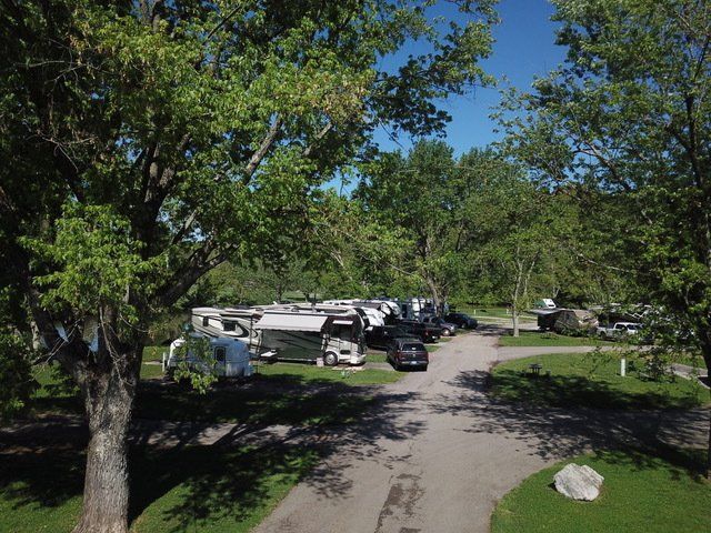 An aerial view of a campground with a lot of rvs parked on the side of the road.