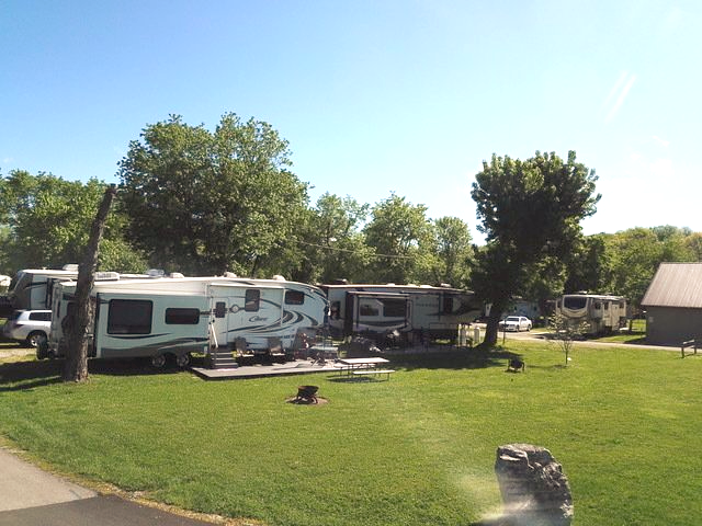 A group of rvs are parked in a grassy area