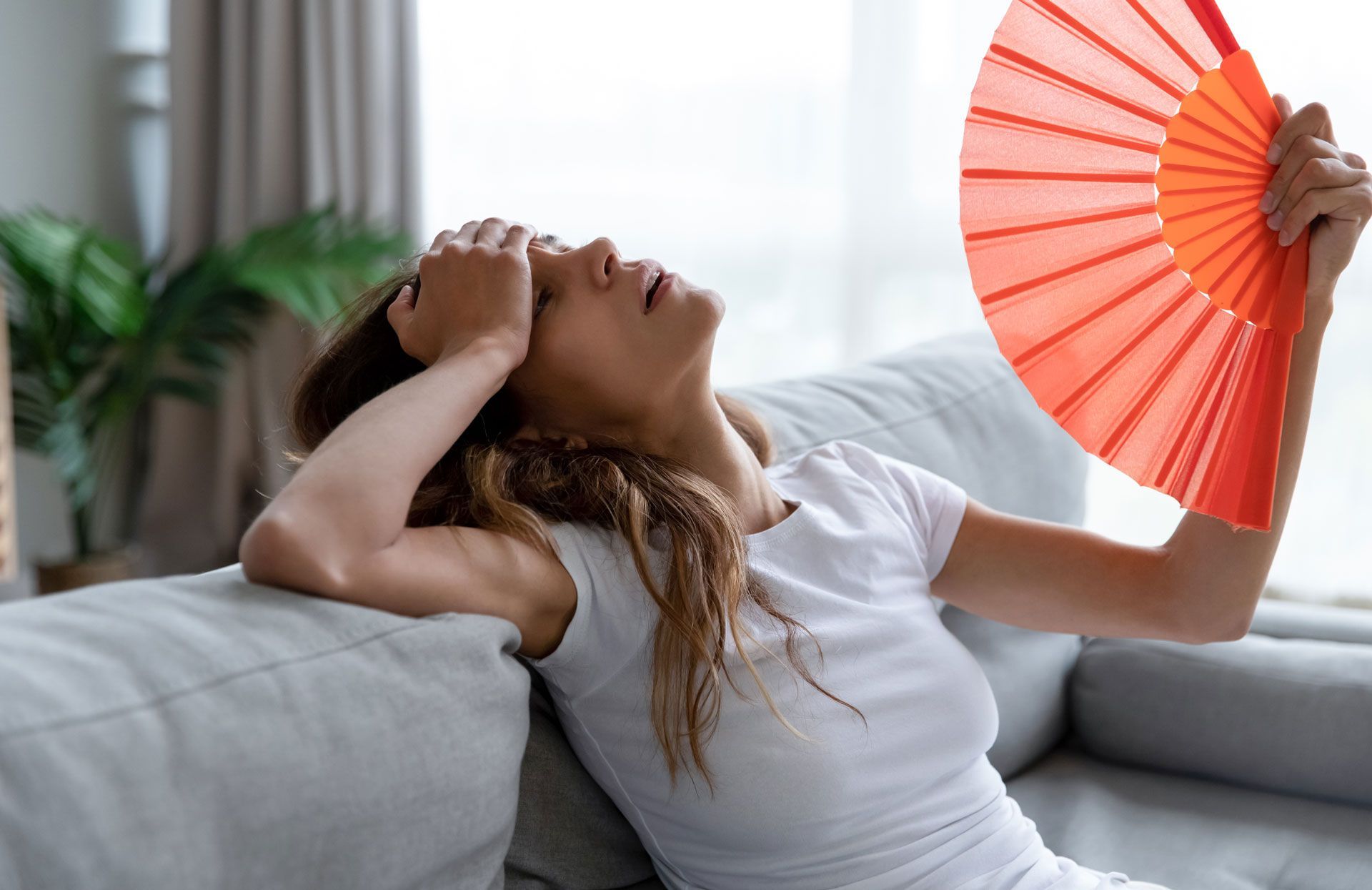 A woman is sitting on a couch dealing with a hangover in Kennesaw.