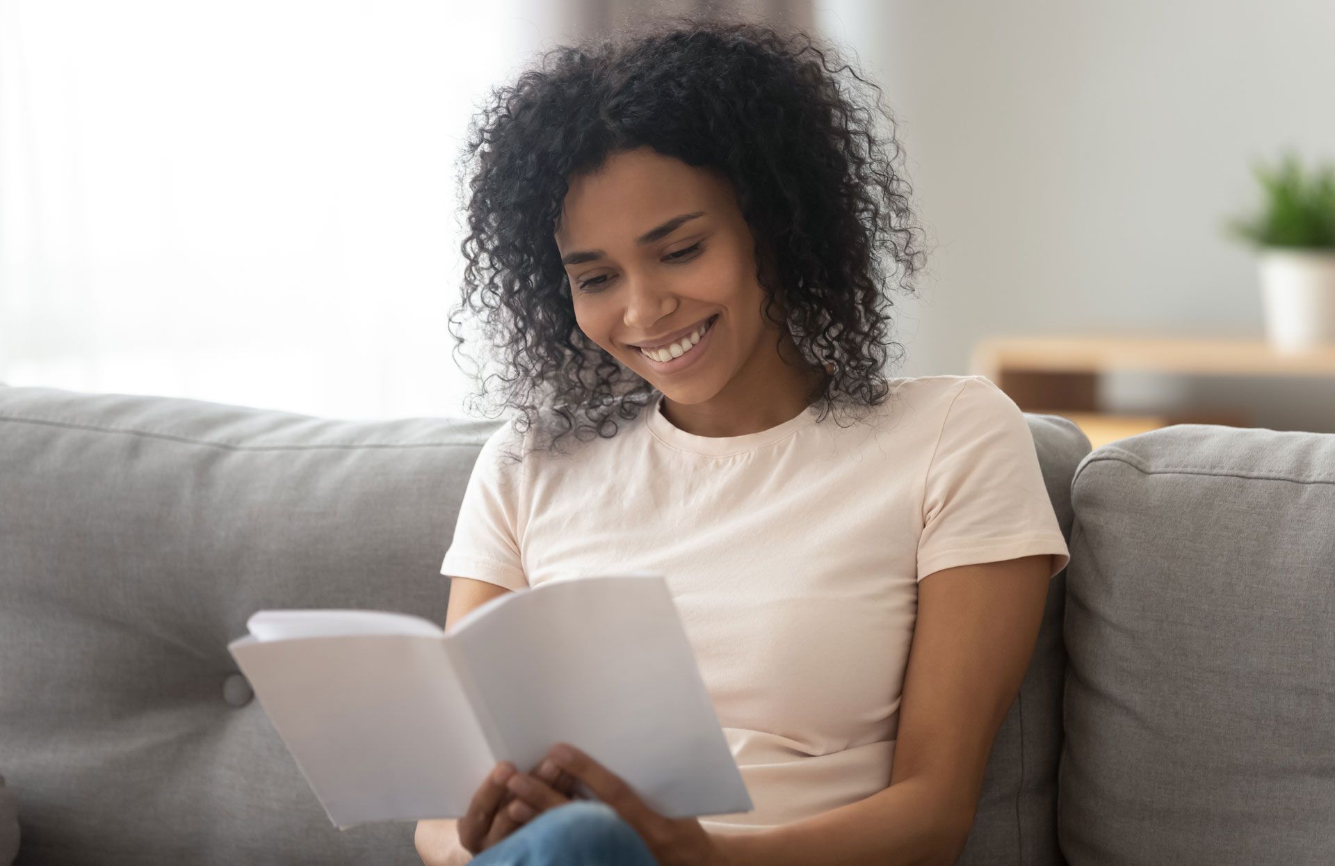A woman is sitting on a couch, reading a book, in Kennesaw.