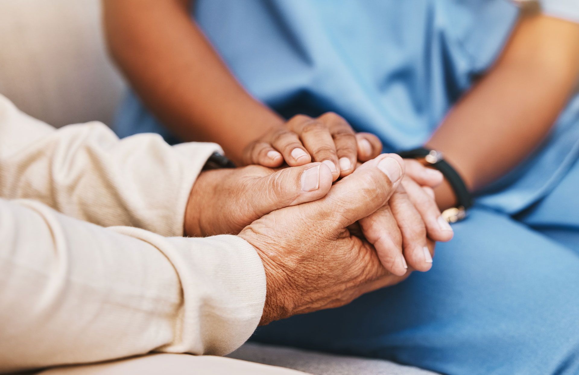 A woman is holding a man's hand to offer cancer support in Kennesaw.