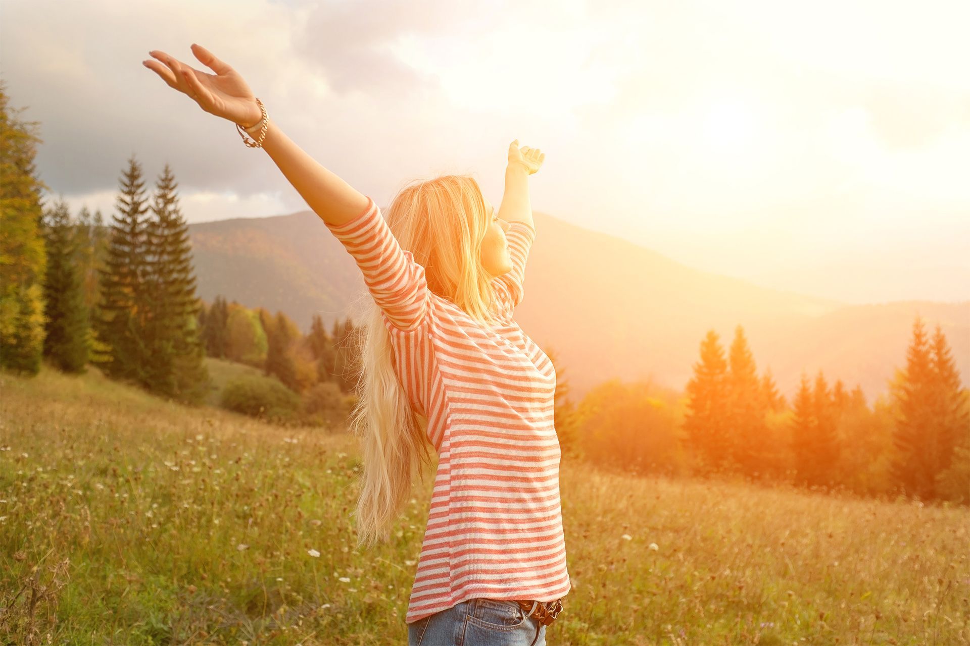 Woman with Hands Up in Mountain Air